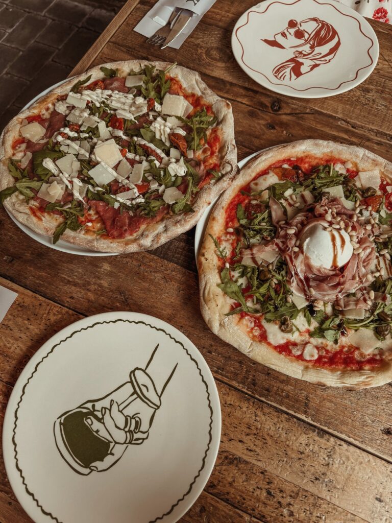 Twee pizza’s op een houten tafel bij een lunchplek in de buurt