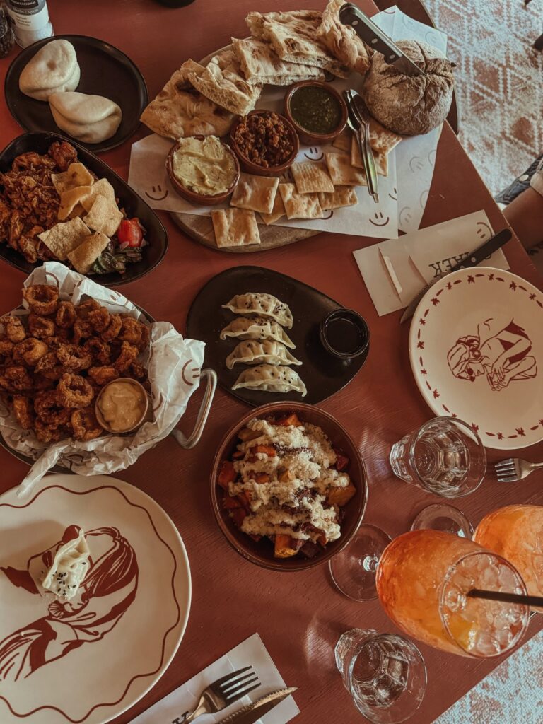 Gedekte tafel met tapas, brood en spritz bij een lunchplek