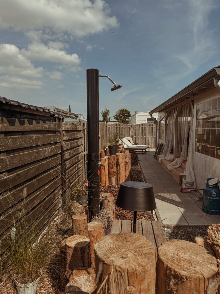 Pad langs de buitendouche naar het terras met ligbedden